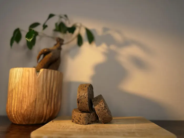 Coffee goat milk soap bars leaning against each other on a wooden board